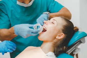 Doctor dentist puts the retractor to the patient